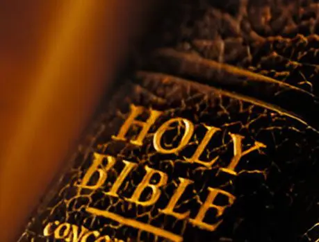 A close up of the word bible on top of an old book.