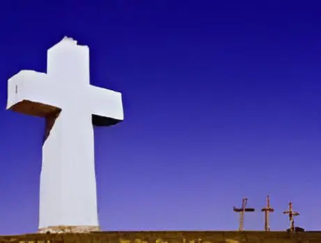 A large cross is on top of the hill.